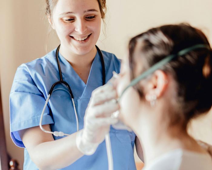 Patientin wird eine Sauerstoffmaske angezogen