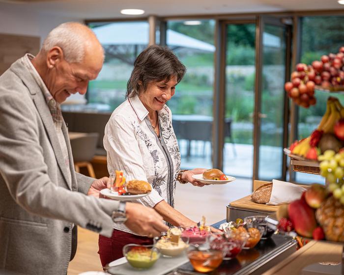 Pärchen, das sich am Frühstücksbuffet bedient