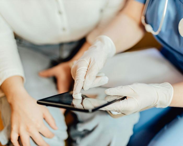Arzt erklärt Patient etwas auf seinem iPad