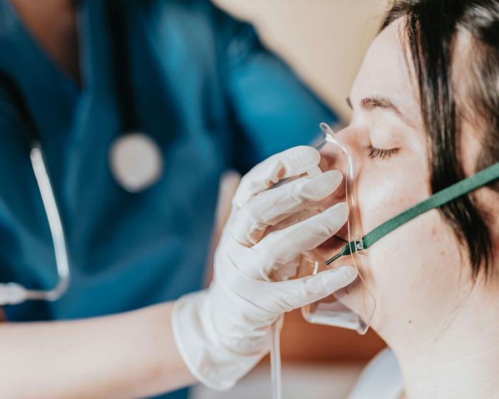 Patientin wird eine Sauerstoffmaske angezogen