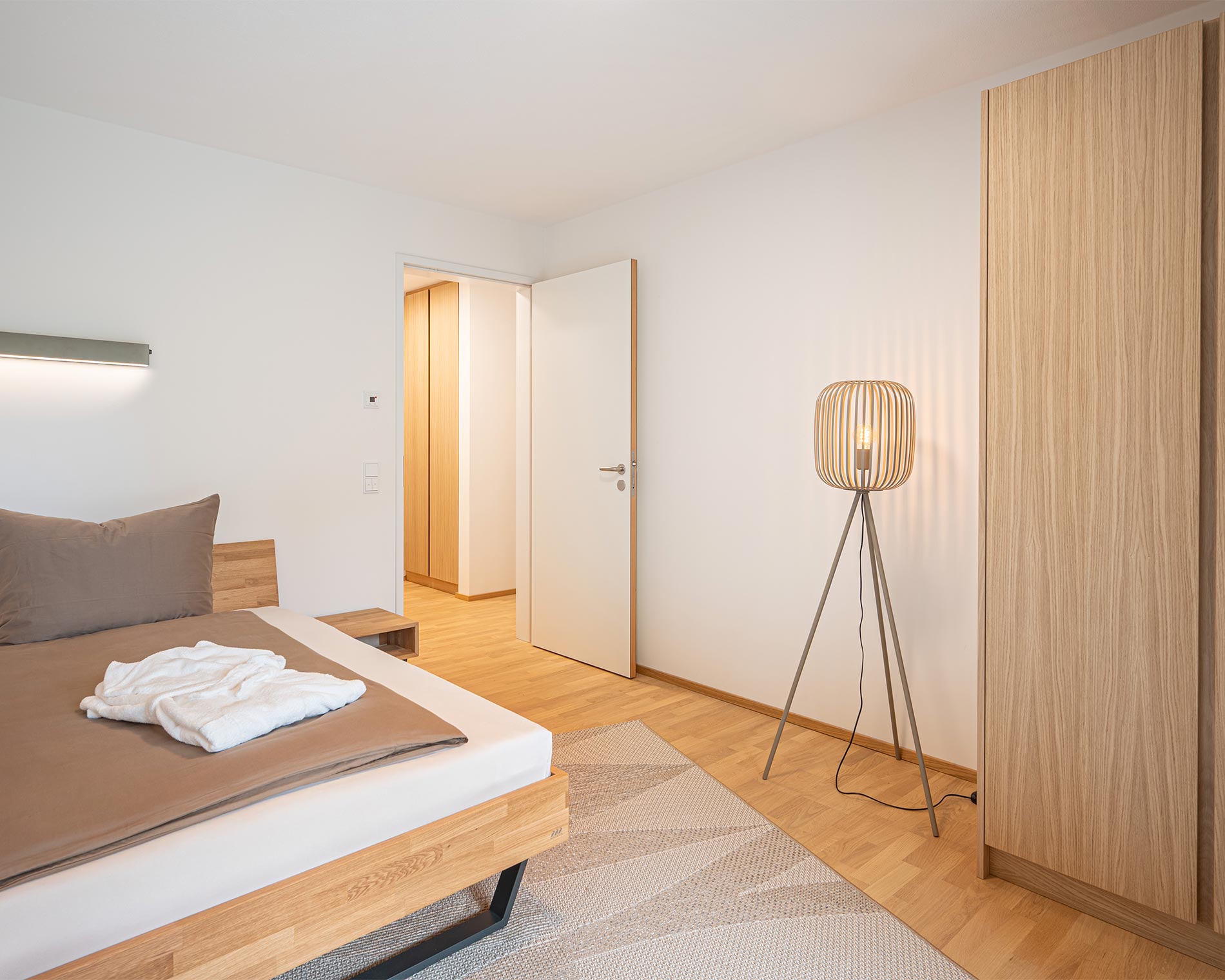 helles geröumiges Schlafzimmer der Suite mit schöner Stehlampe